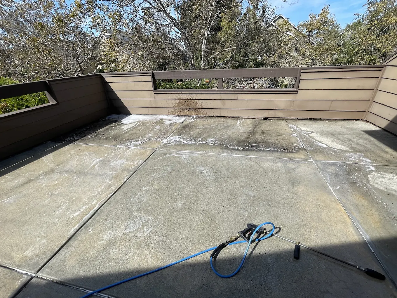 Concrete patio covered with dirt and stains before professional pressure washing and Clean, restored concrete patio after professional pressure washing