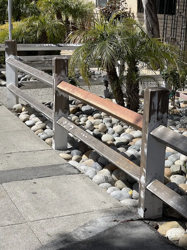 Wooden rail before pressure washing showing dirt and weathering and Wooden rail after pressure washing with noticeably refreshed color and cleanliness